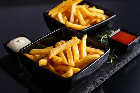 Potatoes fries in the plate on black background.の写真素材