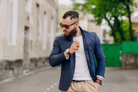 bearded man with e-cigarette outdoorsの写真素材