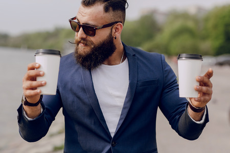 bearded man carrying coffeeの写真素材