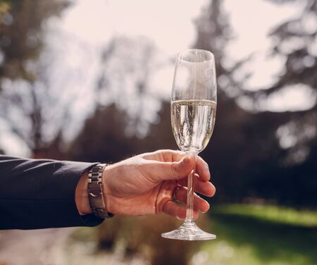 wedding glasses in hands with  champagne sunnyの写真素材