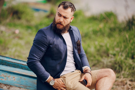 bearded man on the boat with phone summer dayの写真素材