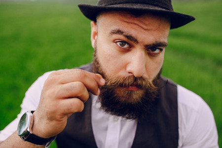 lone bearded man who looks like a millionaire standing in fieldの写真素材
