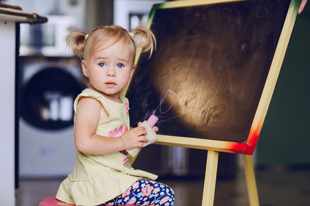 blonde little girl learning to drawの写真素材