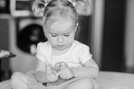 beautiful little girl learns to cook a meal in the kitchenの写真素材