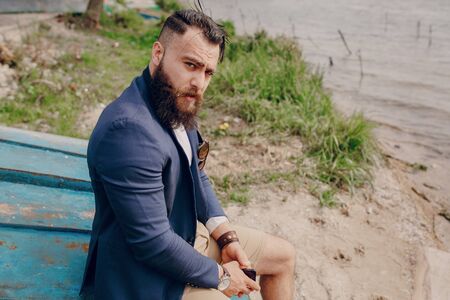 bearded man on the boat with phone summer dayの写真素材