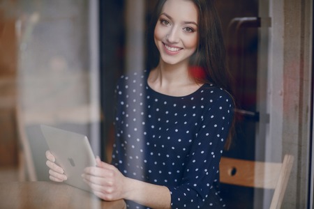 beautiful young girl enjoys phone and tabletの写真素材