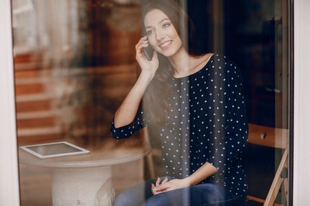 beautiful young girl enjoys phone and tabletの写真素材
