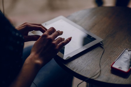 beautiful young girl enjoys phone and tabletの写真素材