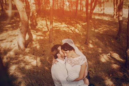 Happy couple whose wedding photo shoot in a golden autumnの写真素材