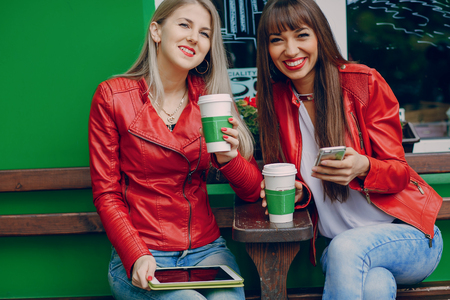 two beautiful girls photographed with gadgets and walk cityの写真素材