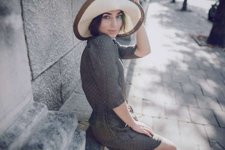 beautiful young model standing in a hat outdoorsの写真素材
