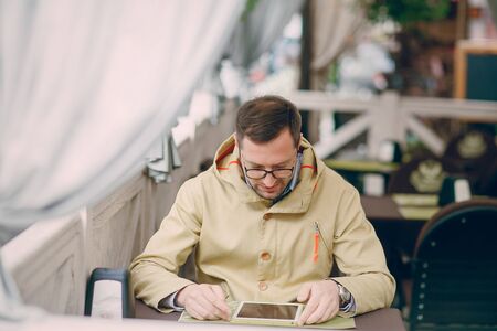 adult man speaks on the phone and writing textの写真素材