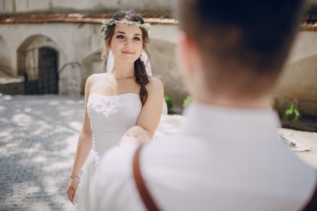 Wedding couple in babochtsi crown and hand in handの写真素材