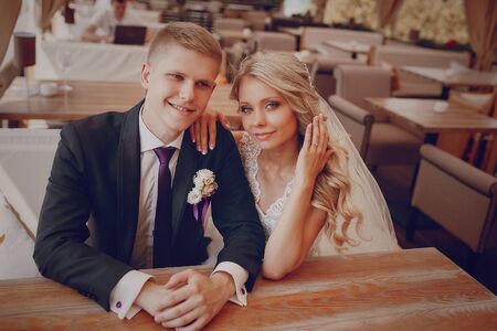 wedding couple sitting in a cafe on their wedding dayの写真素材