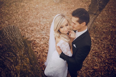 bride walking in golden autumn nature weddingの写真素材