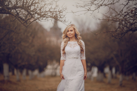 bride walking in golden autumn nature weddingの写真素材