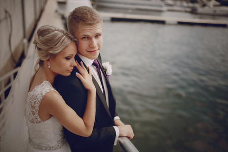 Wedding blond couple walking near the  yachtsの写真素材