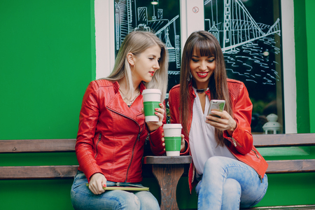two beautiful girls photographed with gadgets and walk cityの写真素材