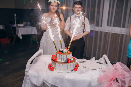 Wedding couple cut a cake in a restaurant
