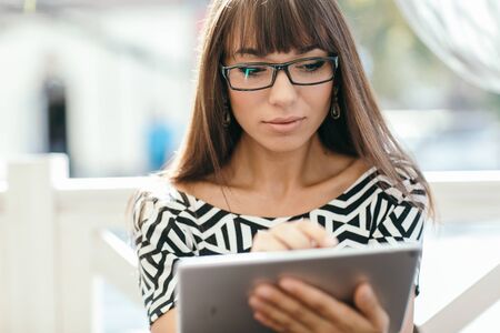 Pretty Girl using tablet phone in cafeの写真素材