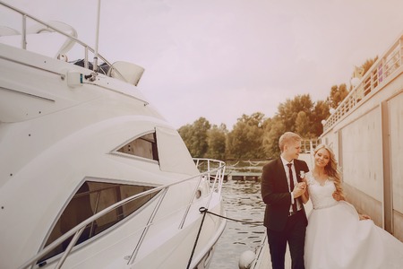 Wedding blond couple walking near the  yachtsの写真素材