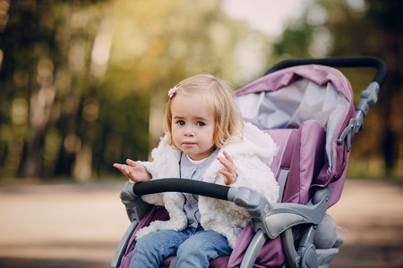 little  and very beautiful girl sitting in the pram and waiting for momの写真素材