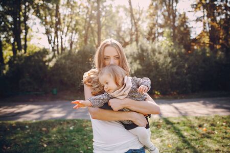 great trendy young mothers walking in the park with his daughters in beautiful clothingの写真素材
