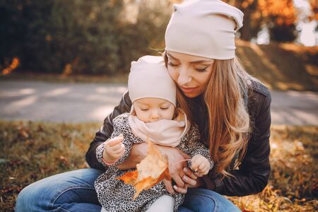 great trendy young mothers walking in the park with his daughters in beautiful clothingの写真素材