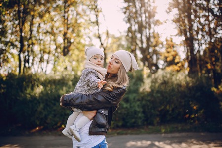 great trendy young mothers walking in the park with his daughters in beautiful clothingの写真素材