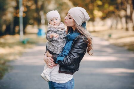 great trendy young mothers walking in the park with his daughters in beautiful clothingの写真素材