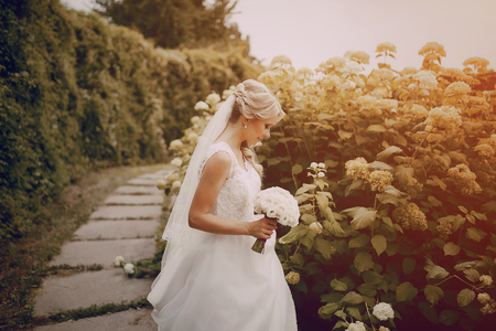 beautiful blond wedding couple walking on reserveの写真素材