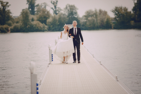 Wedding blond couple walking near the  yachtsの写真素材