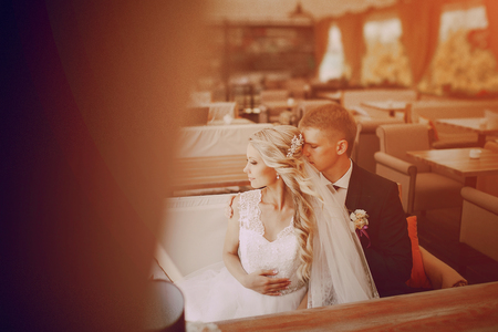 wedding couple sitting in a cafe on their wedding dayの写真素材