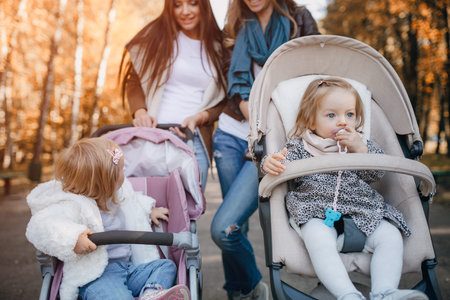 young mother walking with her baby and carries it in a beautiful pram