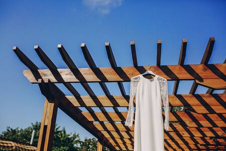 gorgeous wedding dress hanging outside on a sunny dayの写真素材