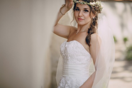 bride poses for photos in wedding dress and wreathの写真素材
