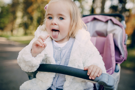 little  and very beautiful girl sitting in the pram and waiting for momの写真素材