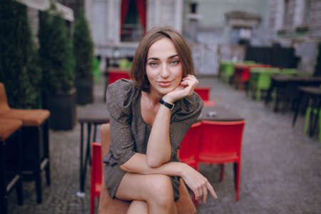 beautiful young model sitting in a cafe on the streetの写真素材