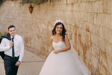 gorgeous wedding couple enjoys a Sunny day in the old town with architectureの写真素材
