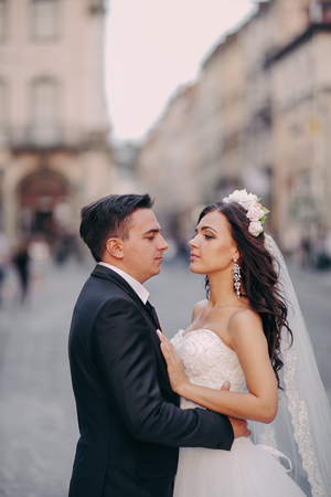 gorgeous wedding couple enjoys a Sunny day in the old town with architectureの写真素材