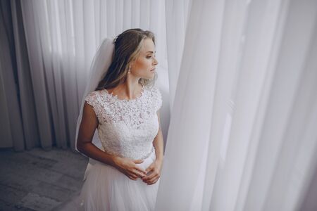 beautiful blonde bride preparing for her weddingの写真素材