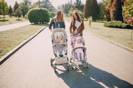 young mother walking with her baby and carries it in a beautiful pramの写真素材