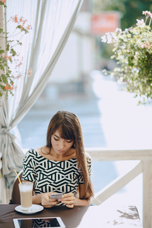Pretty Girl using tablet phone in cafeの写真素材