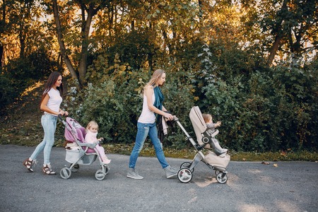 young mother walking with her baby and carries it in a beautiful pramの写真素材