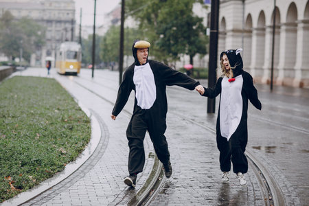 wonderful cheerful couple walking on a rainy Budapest in cat suits