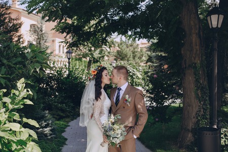 authentic wonderful young couple wedding bride in a wreath of flowers and decorationsの写真素材