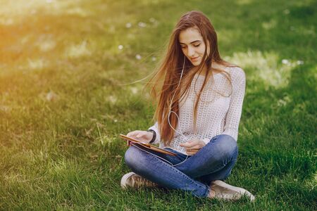 beautiful girl on the street using cell phones, a tablet and walksの写真素材