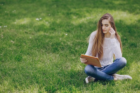 beautiful girl on the street using cell phones, a tablet and walksの写真素材