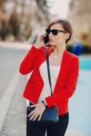 spectacular young brunette outside fashionable and healthy use the phoneの写真素材