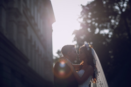 gorgeous wedding couple enjoys a Sunny day in the old town with architectureの写真素材